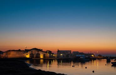 Fototapeta premium Dawn in the small harbor of the fishing village Marzamemi, Sicily, and the enlightened tonnara