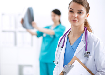 Woman doctor standing with folder at hospital