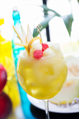 refreshing glass of bright juicy melon smoothie or lemonade with ice on a table at a restaurant with the decor of the bright dishes and pieces of melon