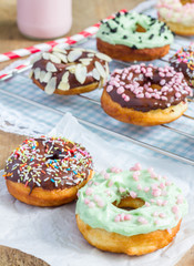 Homemade colorful donuts on parchment paper and cooling rack