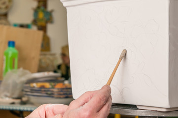 Pottery decorator using graphite to schetch a base drawing for the decoration of a ceramic vase