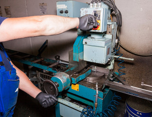 Fototapeta premium Hands working on a metal saw