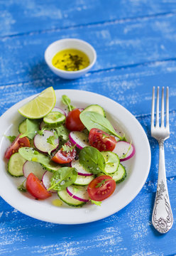 fresh salad with cucumber, radish, cherry tomatoes and spinach 