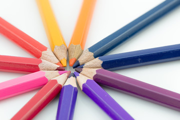 Fototapeta premium Color pencils in arrange in color wheel colors on white backgrou
