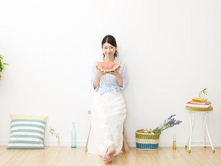 Obraz premium 部屋で西瓜を食べる女性