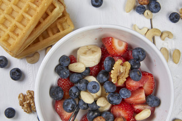 Strawberries, bananas and waffles on a table