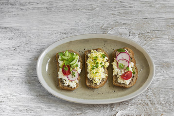 mini toast with cheese, cucumber, radish, tomatoes and egg 