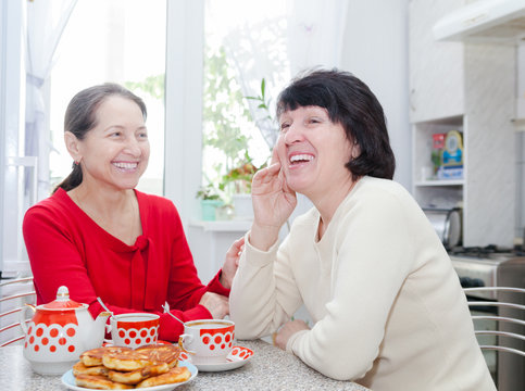 Two Mature Women  Laughing At   Kitchen Table