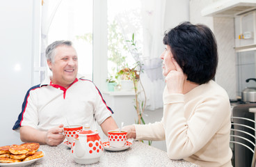 couple in   kitchen drinking tea