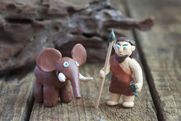 Plasticine world - a caveman with a spear and a stone ax 