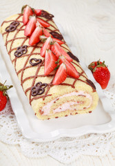 Homemade sponge roll with chocolate patterns, strawberries and cottage cheese cream