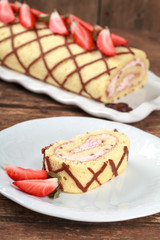 Homemade sponge roll with chocolate patterns, strawberries and cottage cheese cream