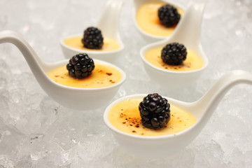  creme brulee desserts topped with fresh berries.