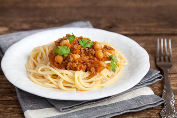 Spaghetti with tomato meat sauce, chickpeas and parsley