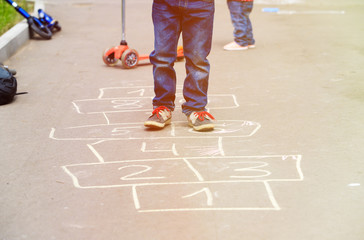 kids playing hopscotch on playground outdoors