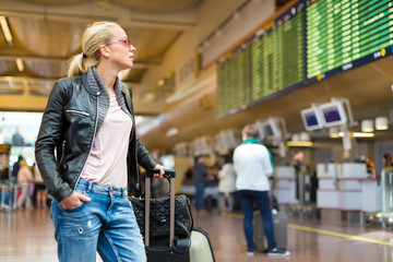 Female traveller checking flight departures board.