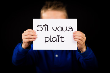 Child holding sign with French words S il Vous Plait - Please