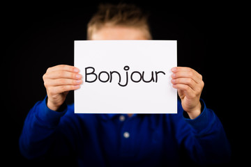 Child holding sign with French word Bonjour - Hello