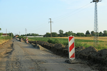 Road works marked with red and white striped road warning posts