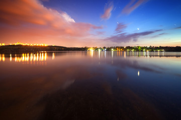 Beautiful night sky at the river with stars and clouds