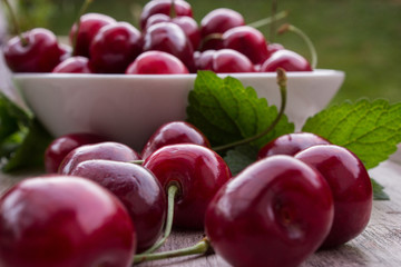 Kirschen in weißer Schale auf Holzuntergrund