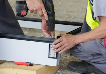 Workers connecting metal profiles for facade