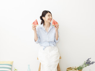 部屋で西瓜を食べる女性