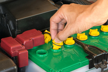 Naklejka premium mechanic the battery of a car