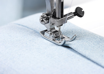 Sewing machine with blue cloth - obrazy, fototapety, plakaty