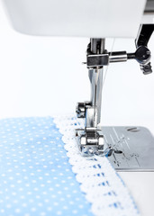 Sewing machine with blue cloth and white lace