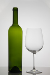 Empty bottle of wine with empty glass of wine on white background