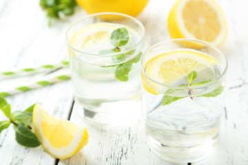 Fresh lemonade with lemon on white wooden background