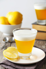 Tasty lemon jelly in glass on grey wooden background