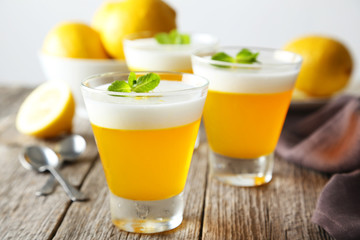 Tasty lemon jelly in glass on grey wooden background