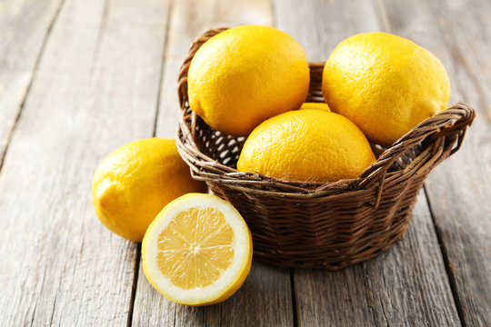 Lemons in basket on grey wooden background