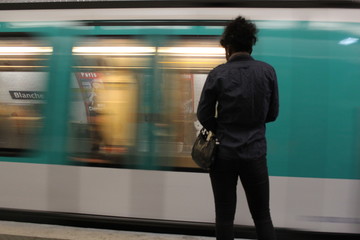 Fototapeta premium Una ragazza di colore ripresa di spalle aspetta la metropolitana