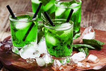 Green cocktail with mint, ice and soda, selective focus