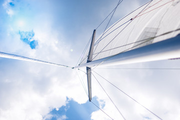 Closeup View of Mid-Size Yacht Mast and Canvas Sail Shot Against
