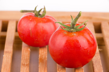 Ripe tomato on wooden grid