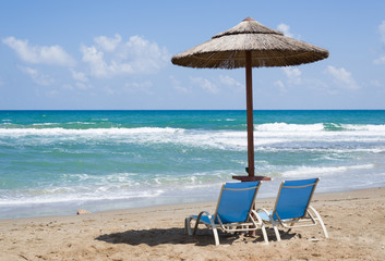 Fototapeta na wymiar Beach chairs and with umbrella and beautiful beach on a sunny da