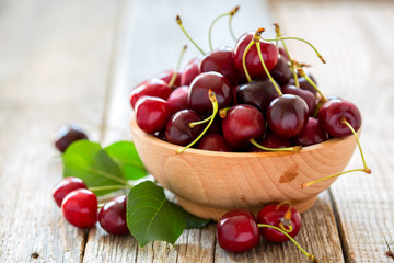 Wooden bowl with ripe cherries.