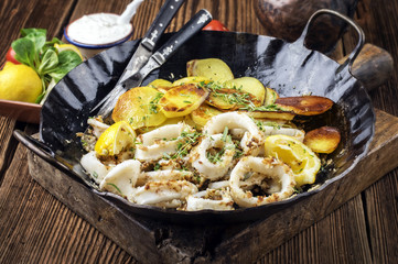 Tintenfischringe mit Bratkartoffel in Pfanne © HLPhoto