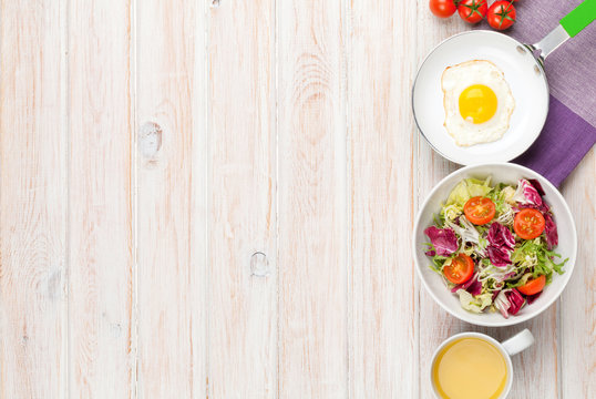 Healthy breakfast with fried egg, tomatoes and salad