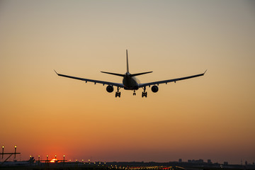 Airplane landing during sunrise.