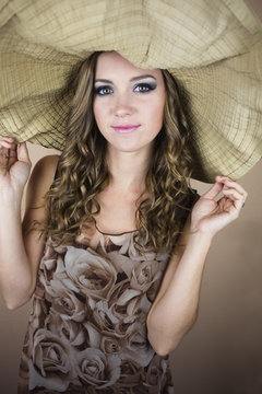 Beautiful young woman wearing big sun hat