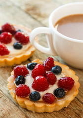 Cup of coffee and sweet cakes with berries
