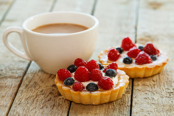 Cup of coffee and sweet cakes with berries