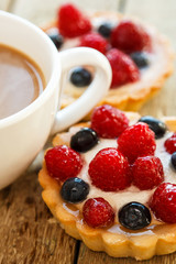 Cup of coffee and sweet cakes with berries