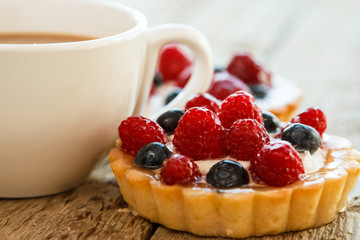 Cup of coffee and sweet cakes with berries