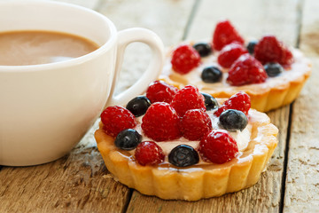 Cup of coffee and sweet cakes with berries
